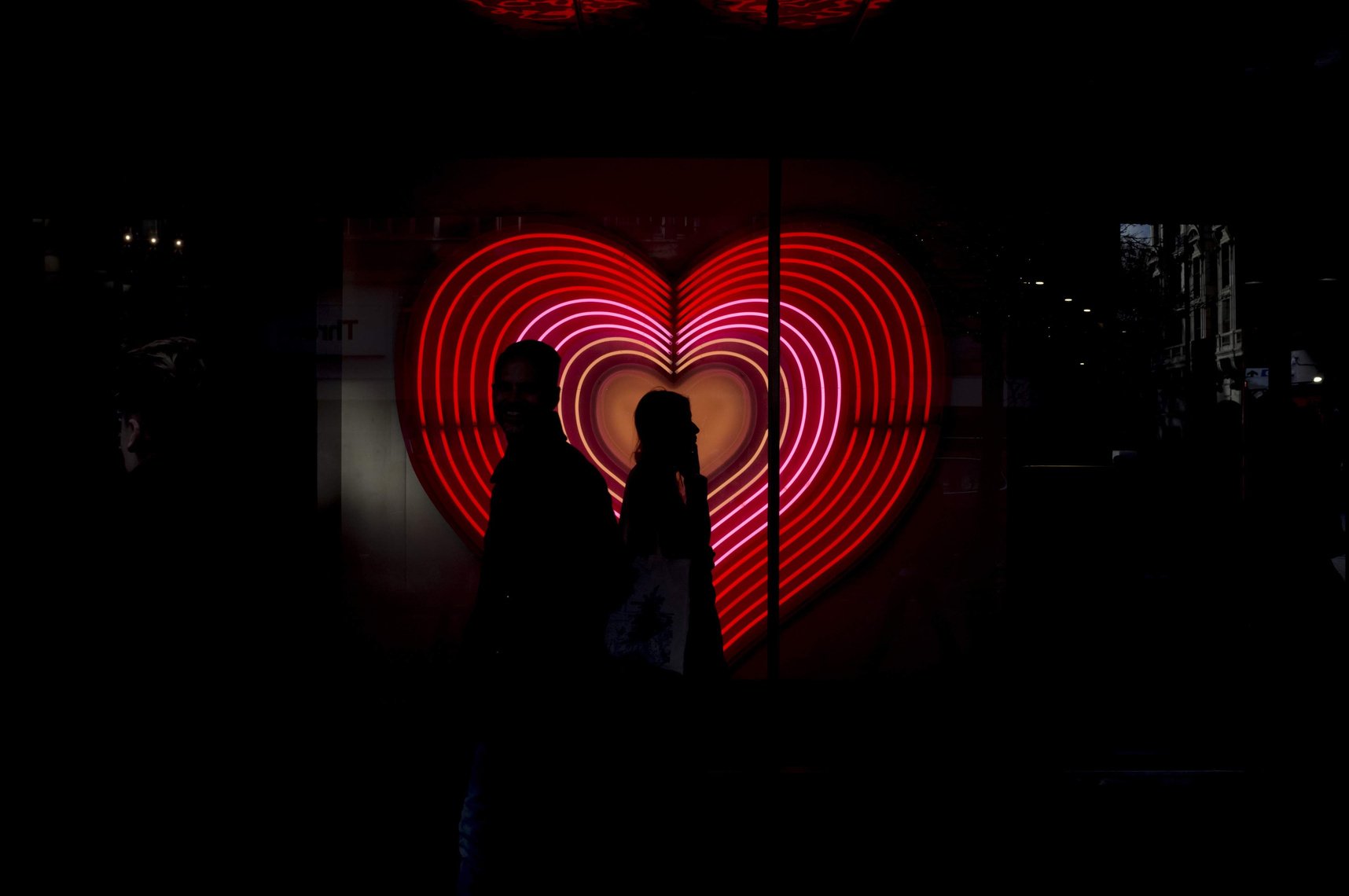 Street photograph of dark outlines of people walking in London.